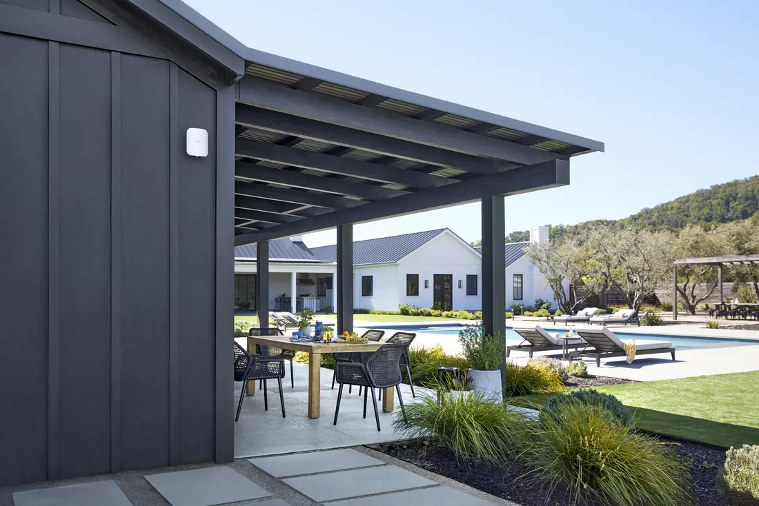 An eero Outdoor 7 mounted on a detached guest house, with the main house behind